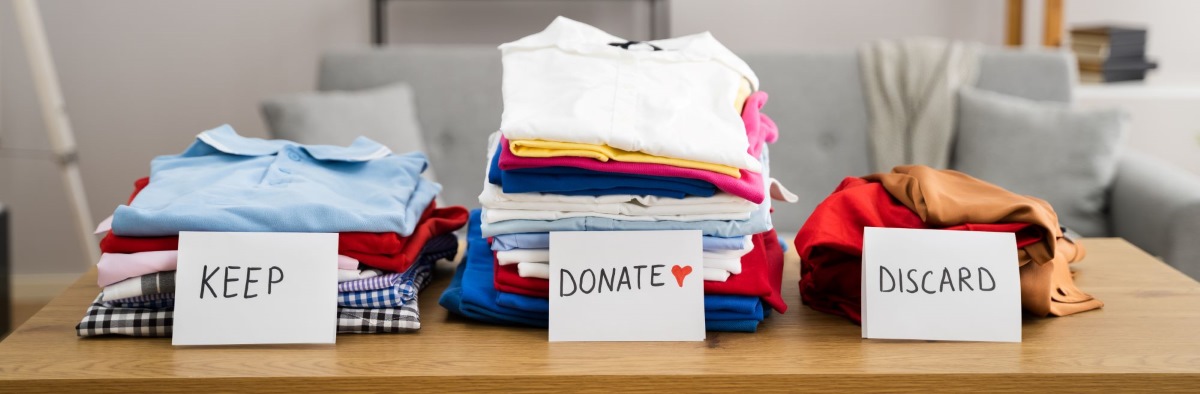Clothing sorted for downsizing move, with keep, toss, donate piles